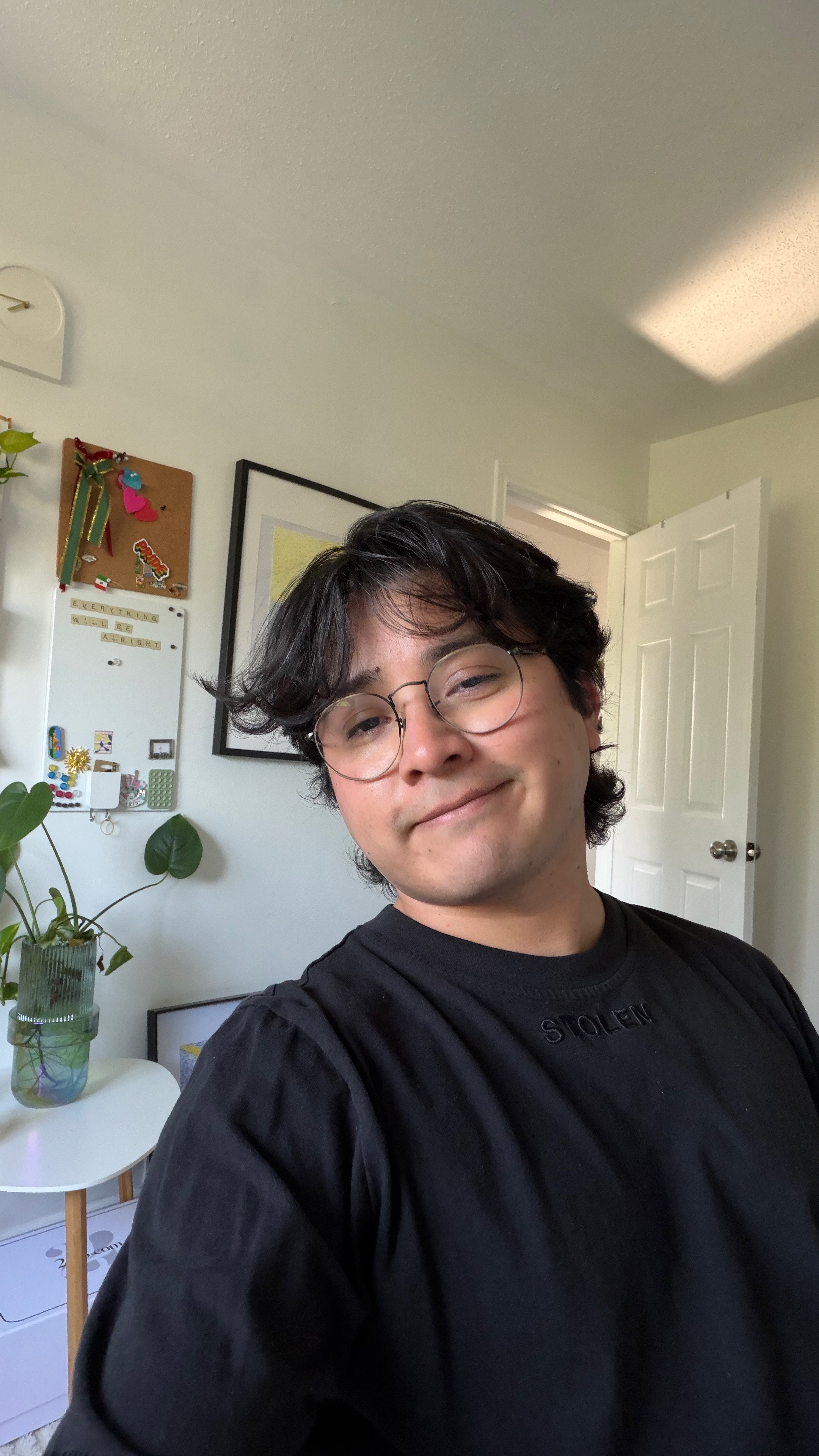Karin Polanco smiling warmly with potted plants and sketchbook